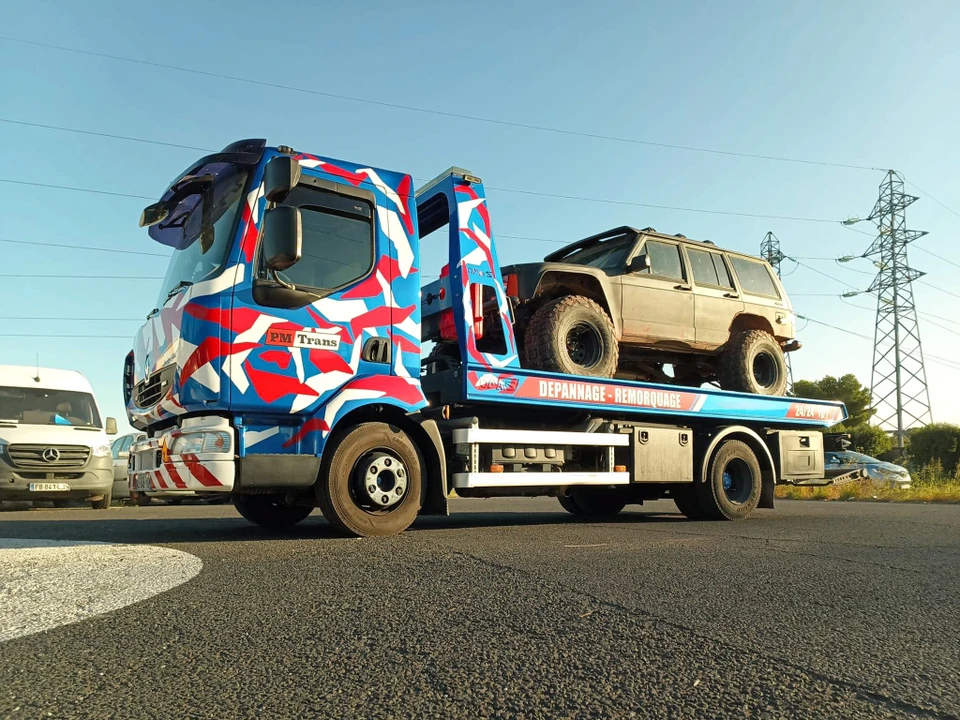 Remorque porte-voitures transportant plusieurs véhicules électriques blancs sur autoroute