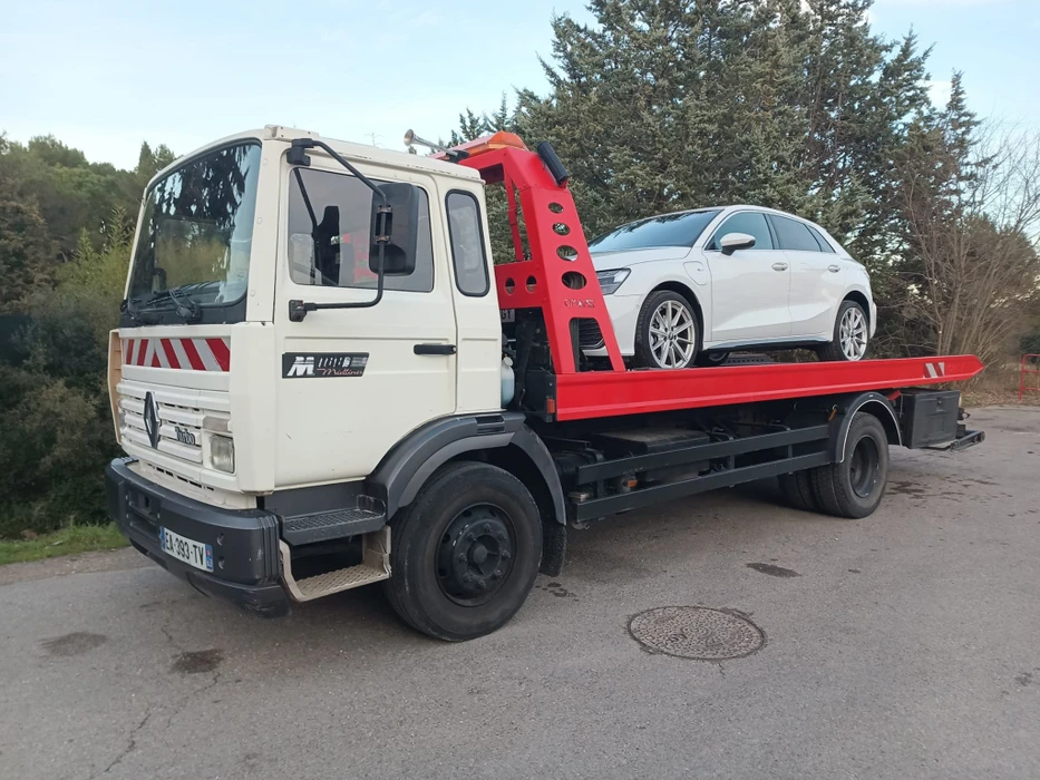 Atelier de maintenance automobile moderne avec camion jaune en réparation, capot relevé exposant le moteur